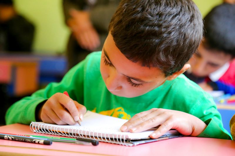 Student writing in a notebook during a personalized learning program