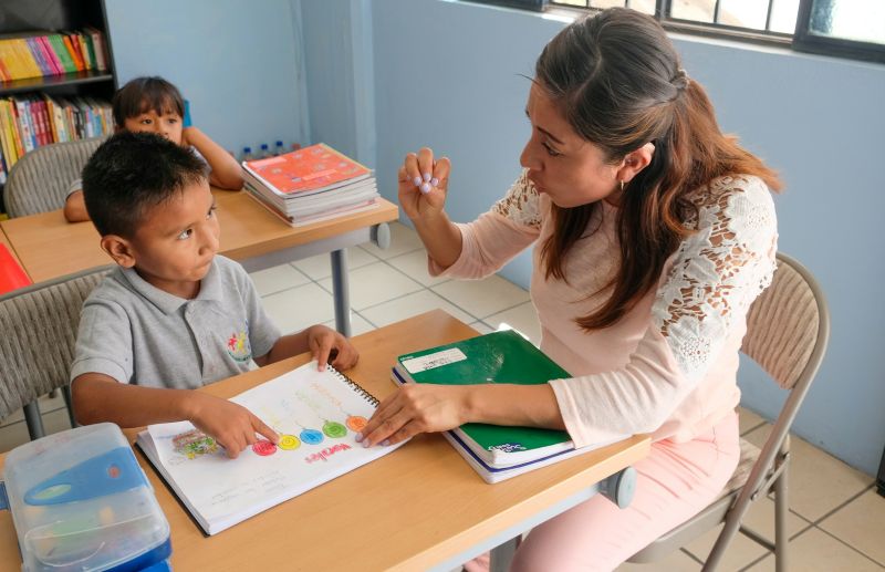 Teacher helping a young student during a personalized learning program session