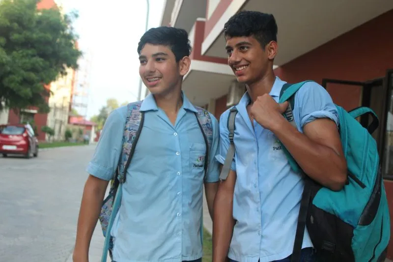 Getting Ready For School as students walk together wearing uniforms and carrying backpacks before heading to class.